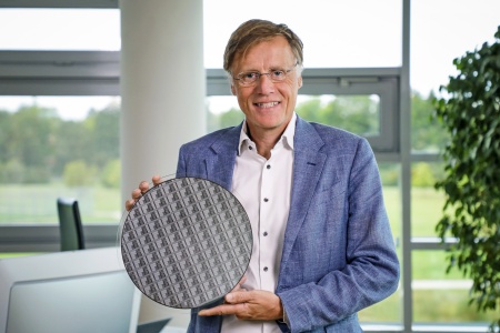 Infineon-CEO Jochen Hanebeck hält einen der weltweit ersten 300-mm-GaN-Power-Wafer, der in einer bestehenden und skalierbaren Hochvolumen-Fertigungsumgebung hergestellt wurde.